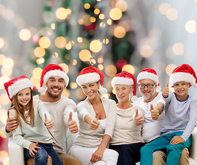 Image showing happy family in santa hats showing thumbs up