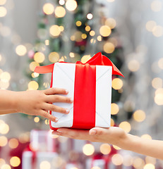 Image showing close up of child and mother hands with gift box