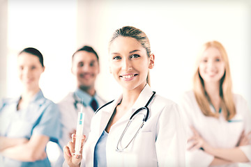 Image showing female doctor holding syringe with injection