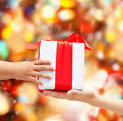 Image showing close up of child and mother hands with gift box