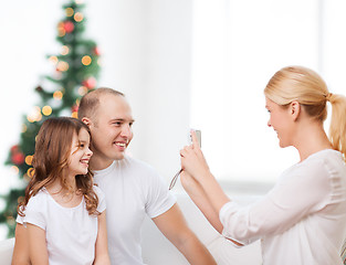Image showing happy family with camera at home