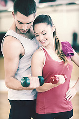 Image showing two smiling people working out with dumbbells