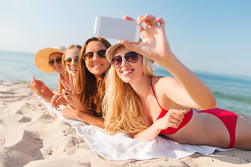 Image showing group of smiling women with smartphone on beach