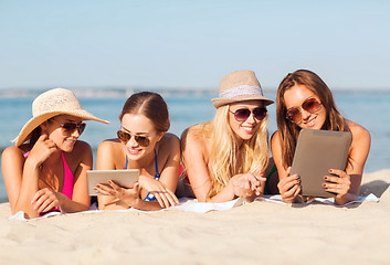 Image showing group of smiling young women with tablets on beach