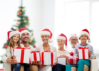 Image showing happy family in santa helper hats with gift boxes