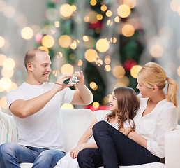 Image showing happy family with camera at home