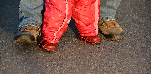 Image showing legs of a man helping baby girl to walk