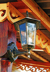 Image showing The lantern on the wall decorated with wooden carvings