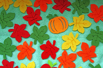 Image showing Bright Maple leaves out of felt on a light green fabric as a bac