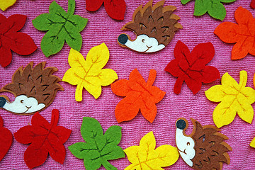 Image showing Hedgehogs and colorful Maple leaves out of felt on a pink fabric