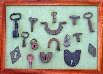 Image showing A collection of very old keys and locks in a wooden frame