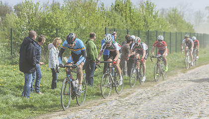 Image showing The Peloton on a Cobblestoned Road