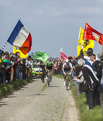 Image showing Two Cyclists on a Cobblestoned Road