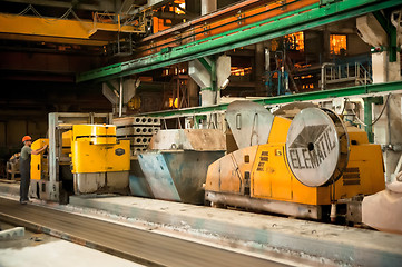 Image showing Worker works at machine on production of plates