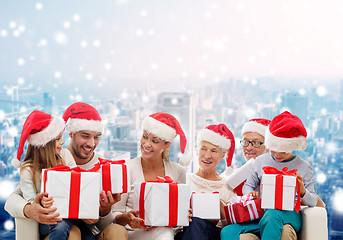 Image showing happy family in santa helper hats with gift boxes