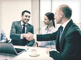 Image showing two businessman shaking hands in office