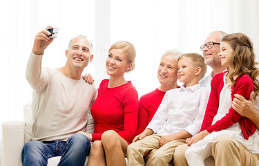 Image showing smiling family with camera at home