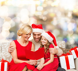 Image showing happy family in santa helper hats with gift boxes