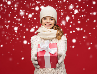 Image showing girl in hat, muffler and gloves with gift box