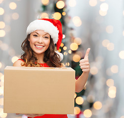 Image showing smiling woman in santa helper hat with parcel box