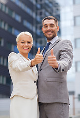 Image showing smiling businessmen showing thumbs up
