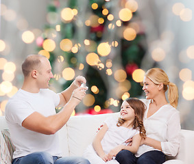 Image showing happy family with camera at home