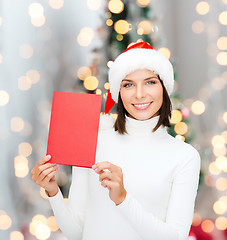 Image showing smiling woman in santa hat with greeting card