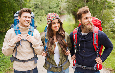 Image showing group of smiling friends with backpacks hiking