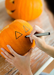 Image showing close up of woman with pumpkins at home