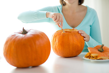 Image showing close up of woman with pumpkins at home