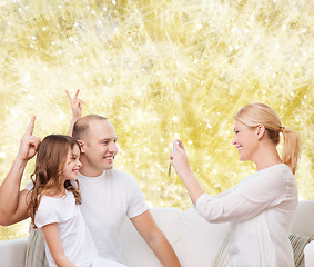 Image showing happy family with camera at home