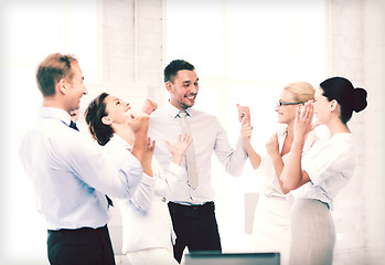 Image showing business team celebrating victory in office