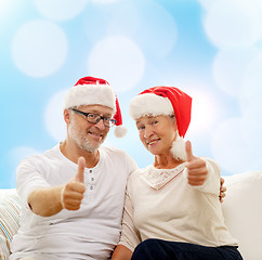 Image showing happy senior couple in santa helper hats