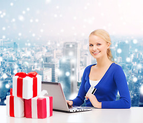 Image showing smiling woman with credit card and laptop