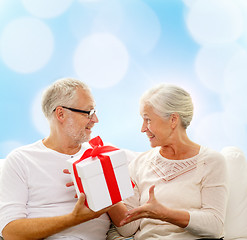 Image showing happy senior couple with gift box at home