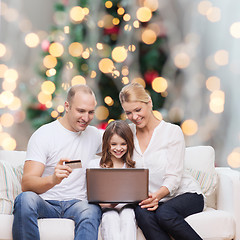 Image showing happy family with laptop computer and credit card