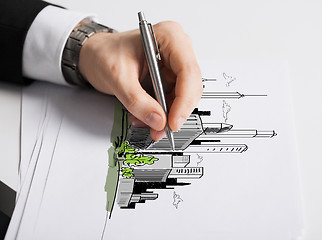 Image showing close up of male hand with pen drawing graph