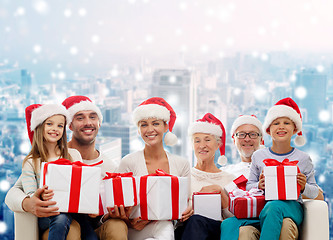 Image showing happy family in santa helper hats with gift boxes