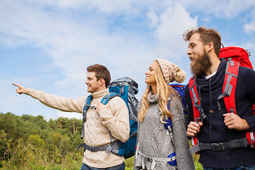 Image showing group of smiling friends with backpacks hiking