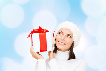 Image showing smiling woman in santa helper hat with gift box