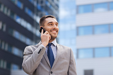 Image showing smiling businessman with smartphone outdoors