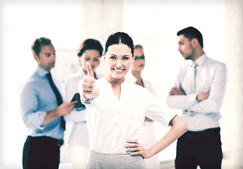 Image showing businesswoman in office showing thumbs up