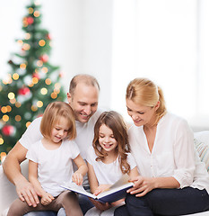 Image showing happy family with book at home