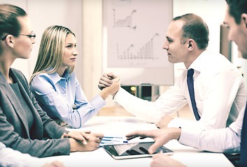 Image showing businesswoman and businessman arm wrestling