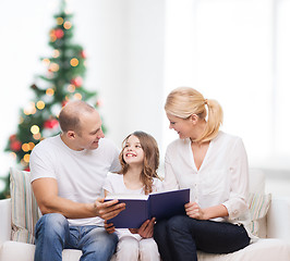 Image showing happy family with book at home