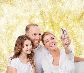 Image showing happy family with camera at home