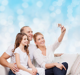 Image showing happy family with camera at home