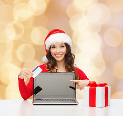 Image showing smiling woman with credit card and laptop