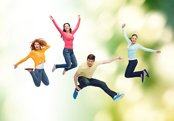 Image showing group of smiling teenagers jumping in air