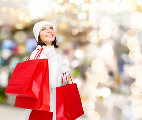 Image showing smiling young woman with red shopping bags